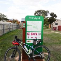 End of the day in Moonambel, Lexie resting against the sign for the Pyranees Cycling Trail